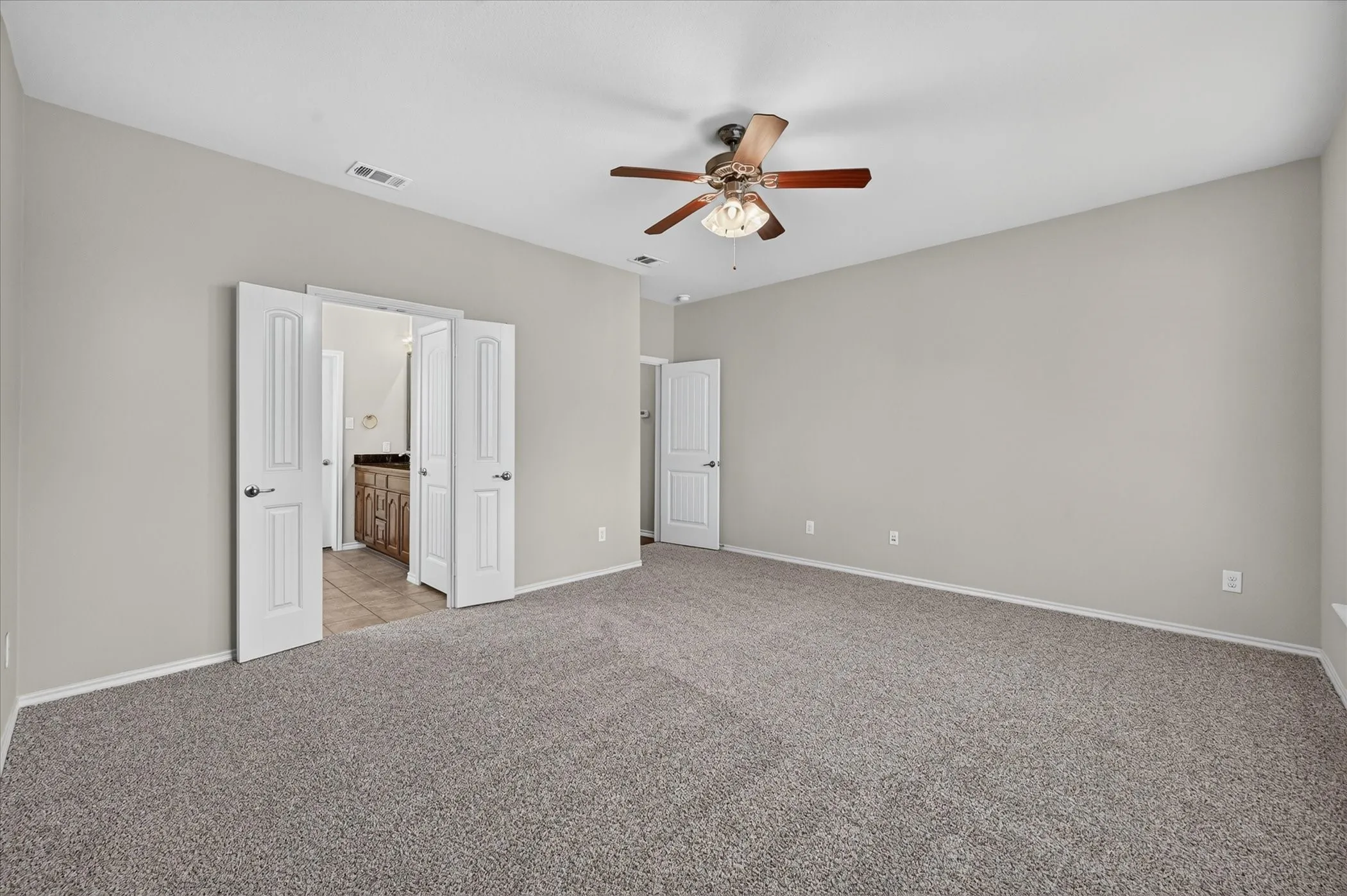 Carpeted room with a ceiling fan, light gray walls, and white trim
