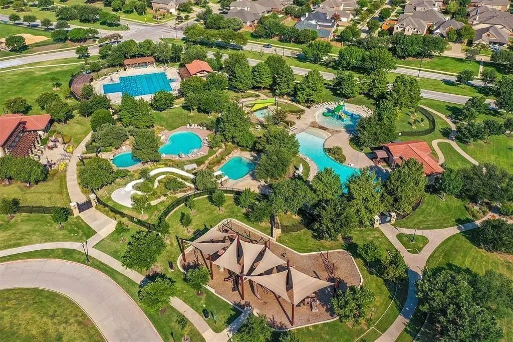 Community amenities featuring multiple swimming pools, water slides, a lap pool, a covered playground, and extensive green spaces