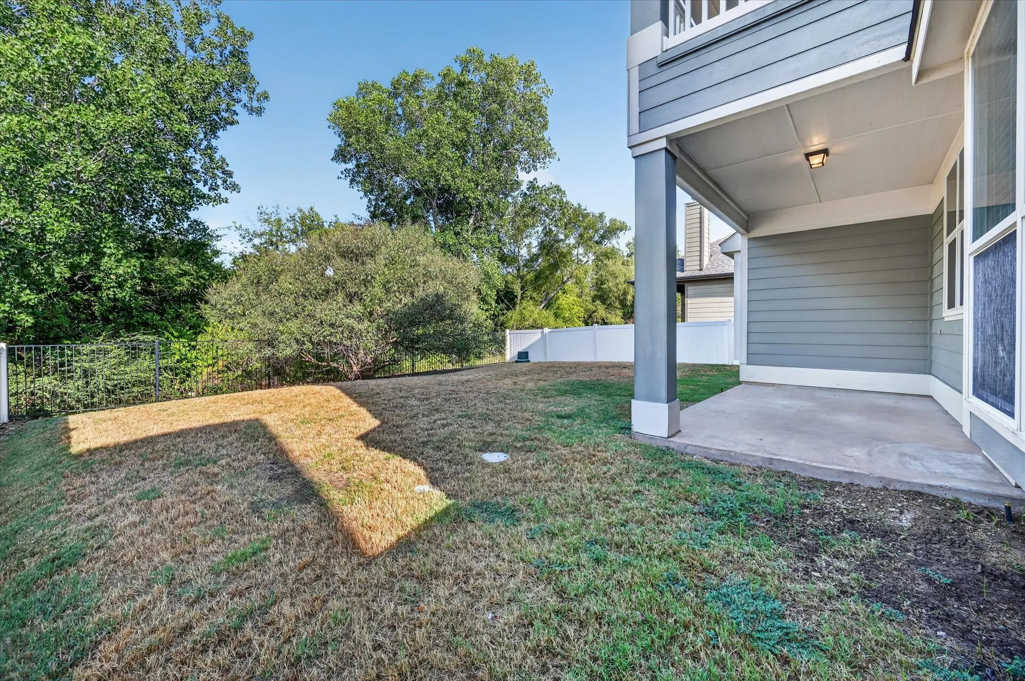 Covered concrete patio with an attached exterior light fixture and siding exterior