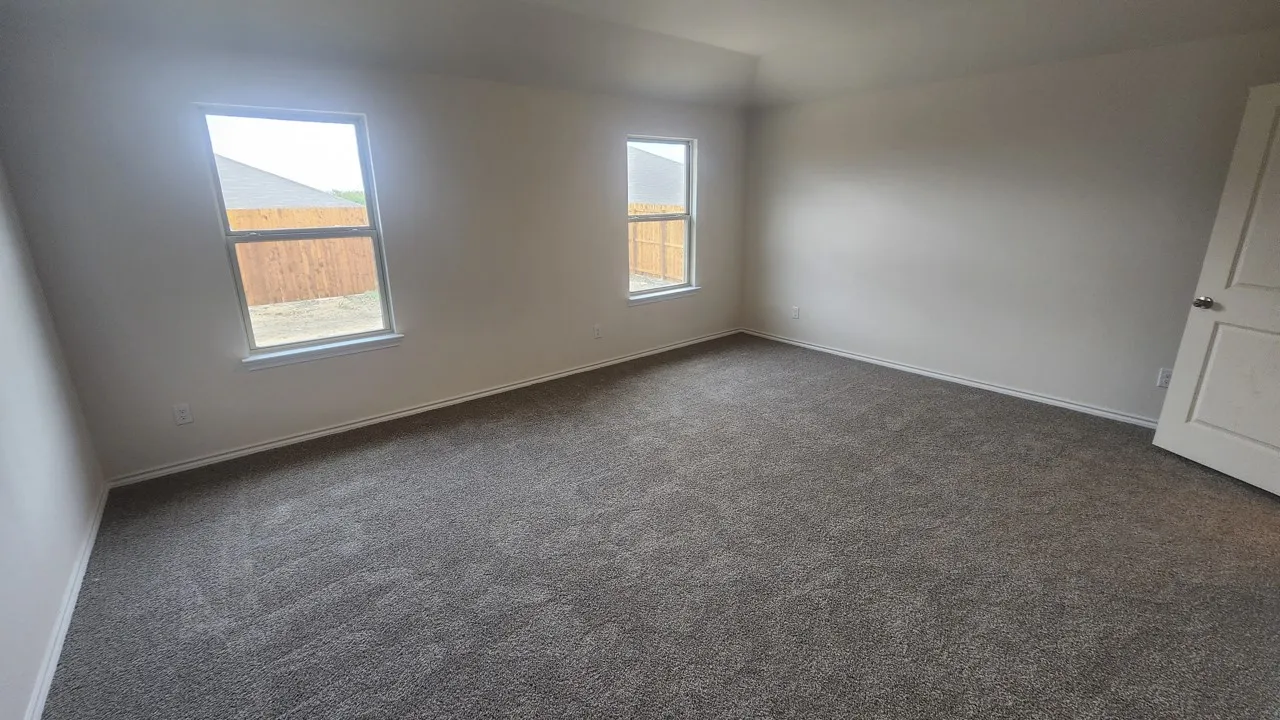 Spacious room with plush gray carpeting, white painted walls, and two large​​‌​​​​‌​​‌‌​‌‌​​​‌‌​‌​‌​‌​​​‌​​ windows