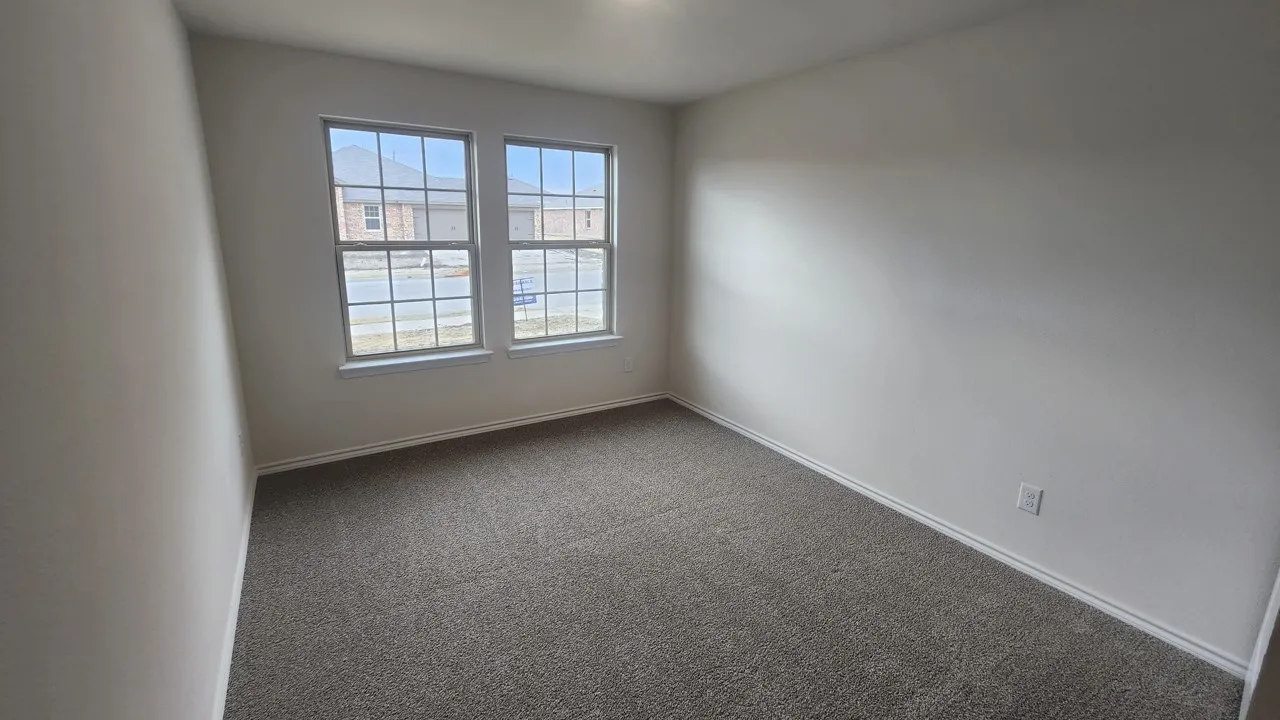 Neutral wall paint, plush carpet, and two double-hung windows