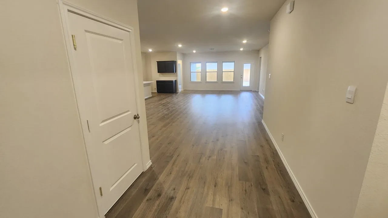 Wood-finish flooring throughout, recessed lighting, and multiple windows providing ambient light