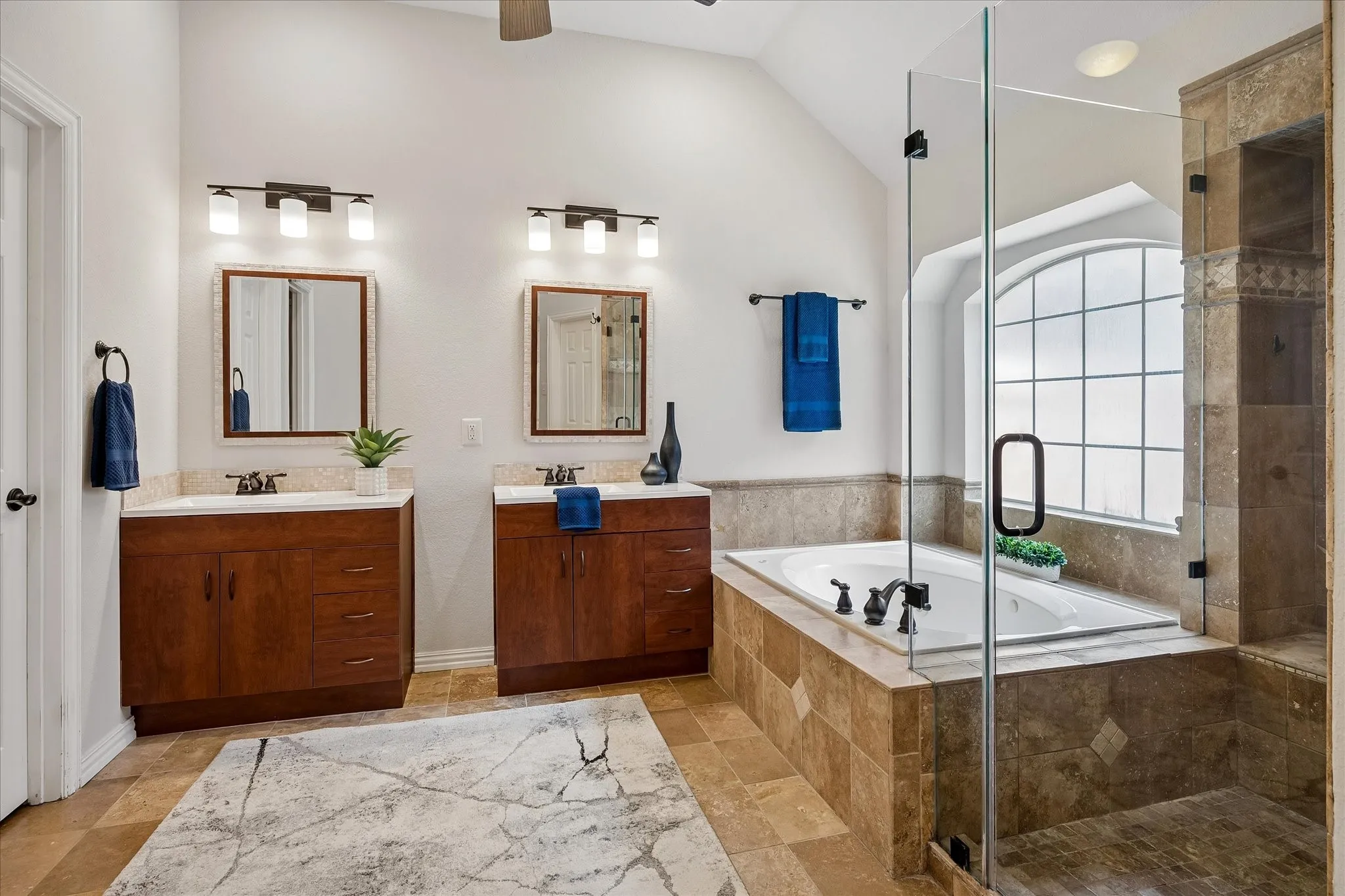Double vanity with wood-finish cabinetry and undermount sinks