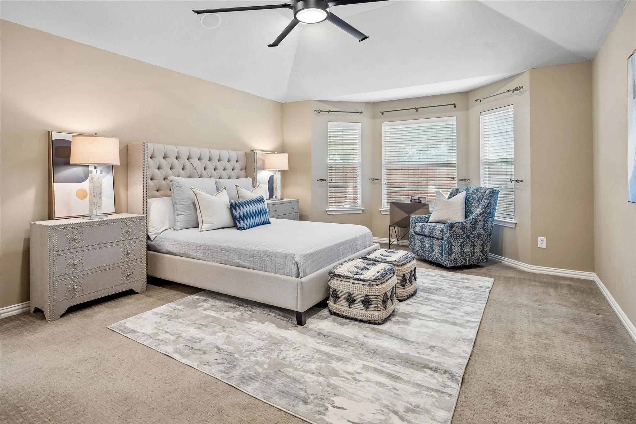 Vaulted ceiling with a ceiling fan, bay window with blinds, and wall-to-wall carpeting