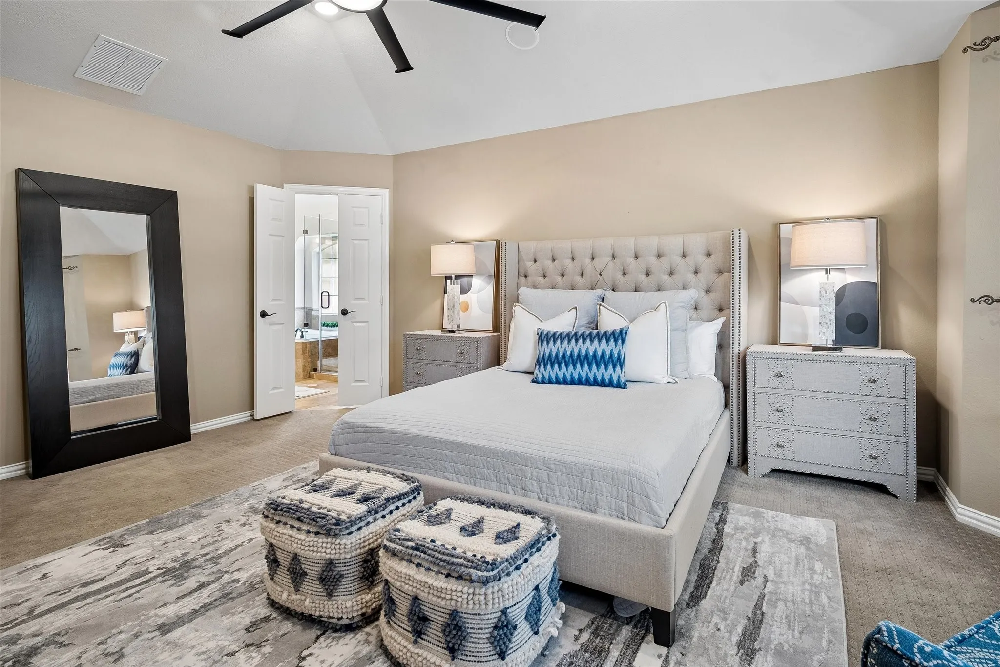 Vaulted ceiling with a contemporary ceiling fan, neutral wall tones, carpet flooring, and double panel doors leading to an adjoining space