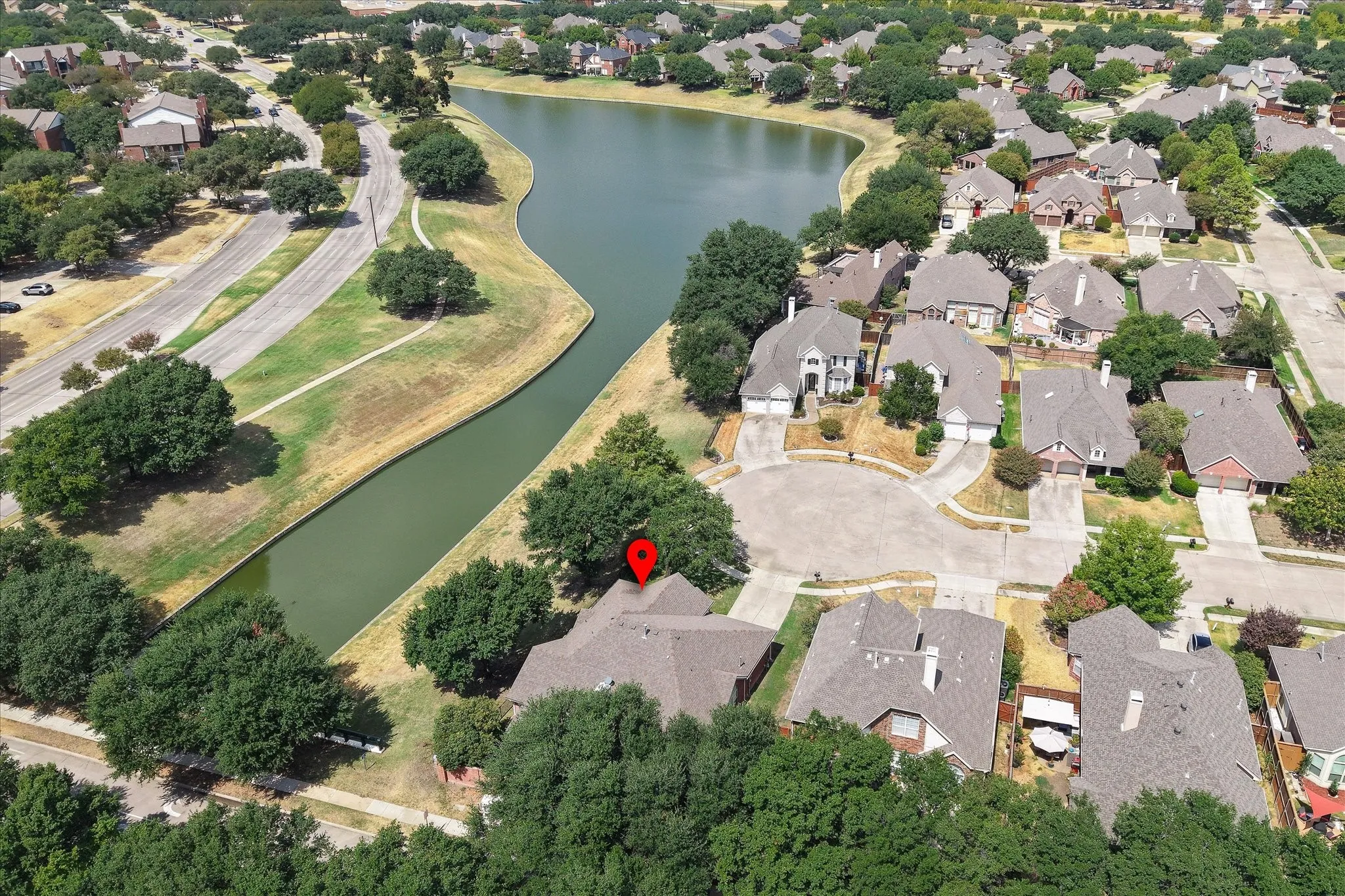Residential property situated on a cul-de-sac, bordering a natural water feature, with mature trees