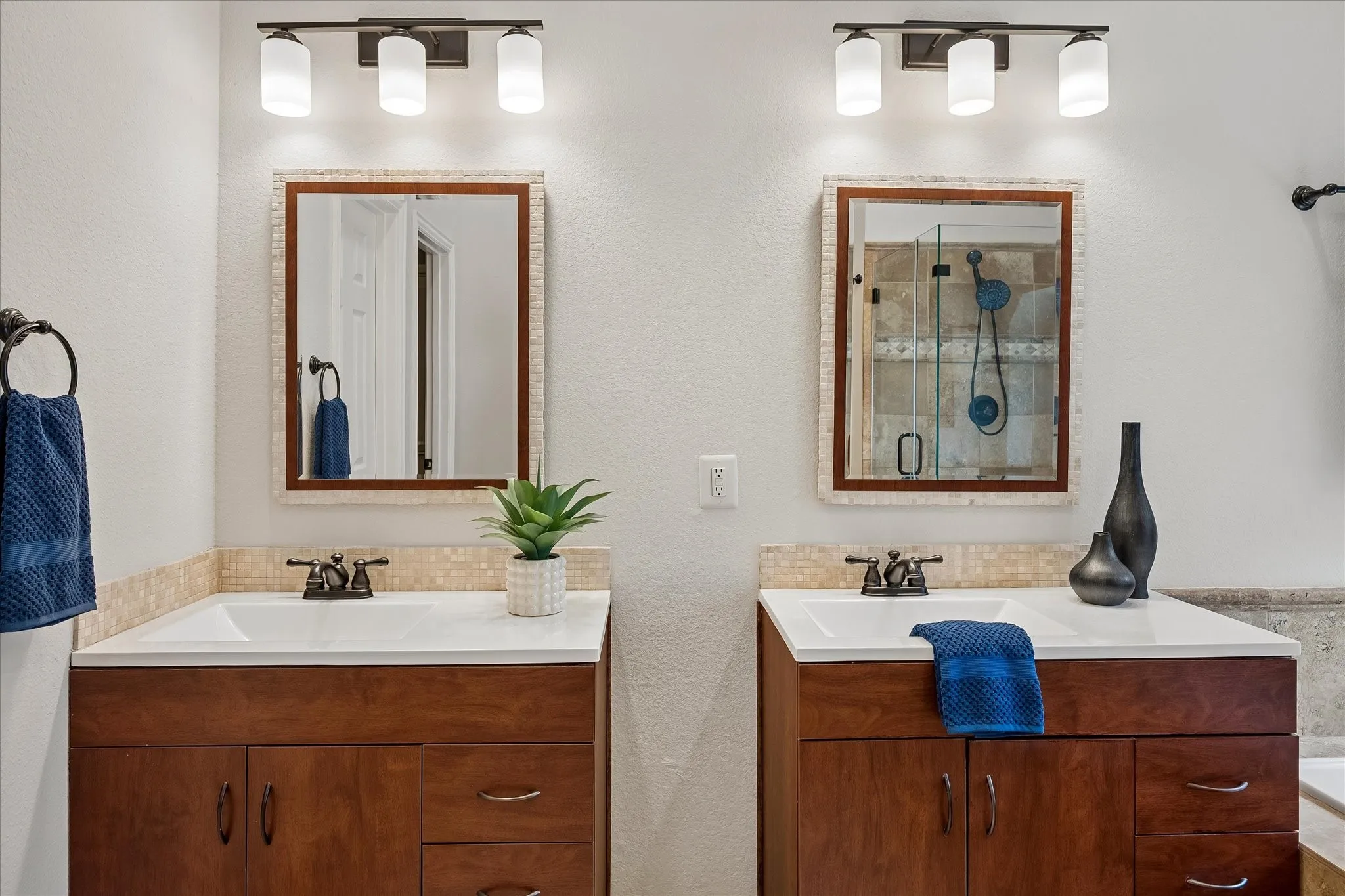 Dual wood-finish vanities with white countertops and integrated sinks