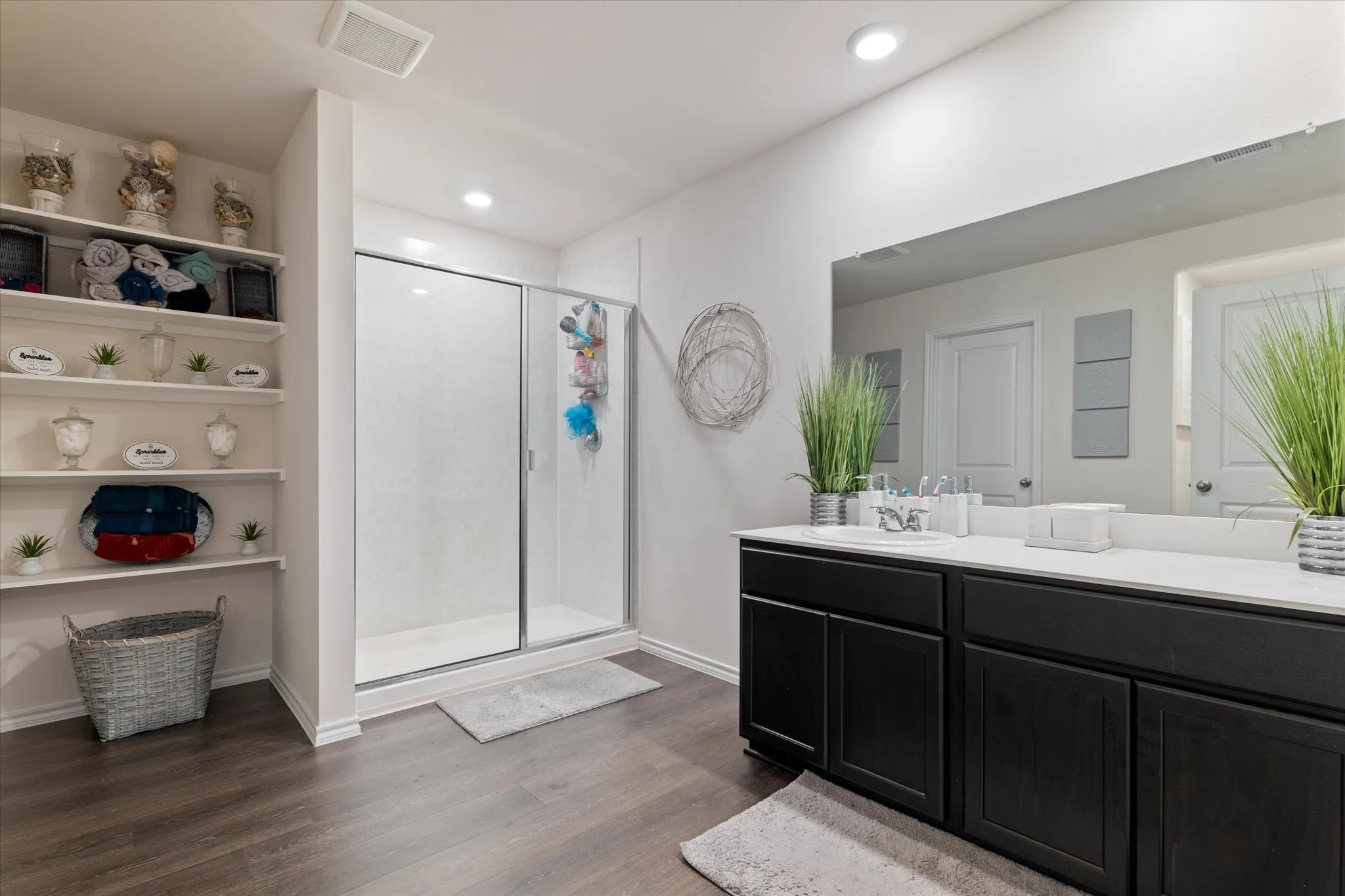 Full bathroom with a shower stall, dark wood finished floors, vanity, and recessed lighting