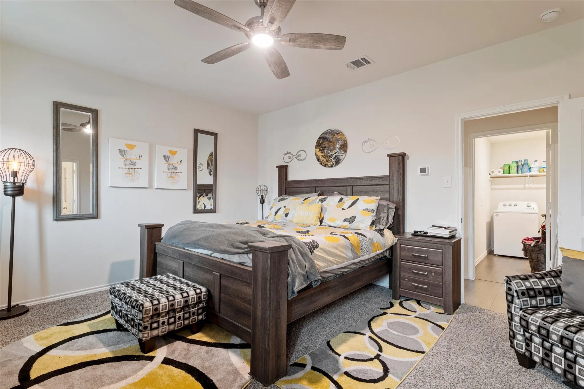 Bedroom featuring washer / clothes dryer, ceiling fan, light carpet, and light tile patterned floors