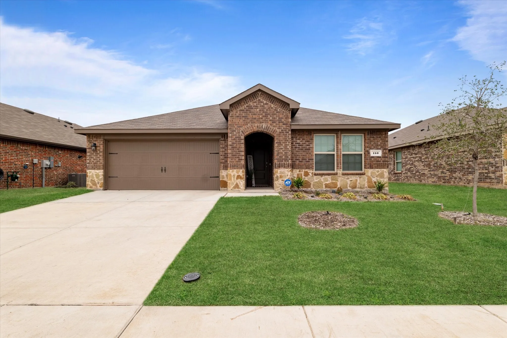 Single story home featuring brick siding, a front lawn, and roof with shingles