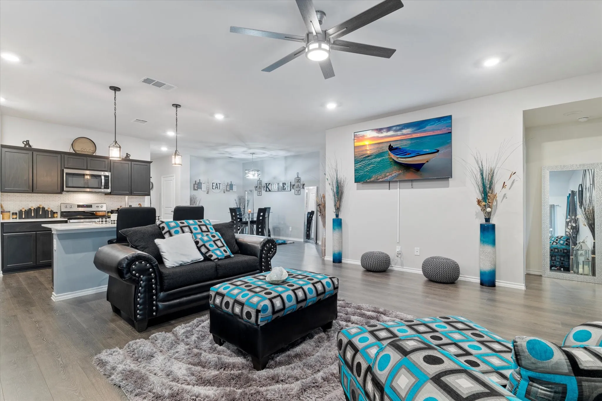 Living room with dark wood-type flooring, recessed lighting, and a ceiling fan