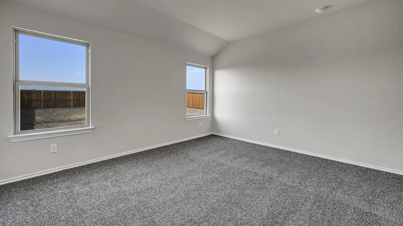 Vaulted ceiling, two windows, neutral wall tones, gray carpeting, and white trim