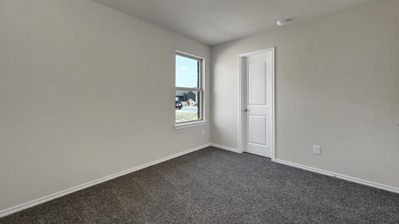 Plush carpet flooring, neutral paint palette, white trim, and a window for natural light