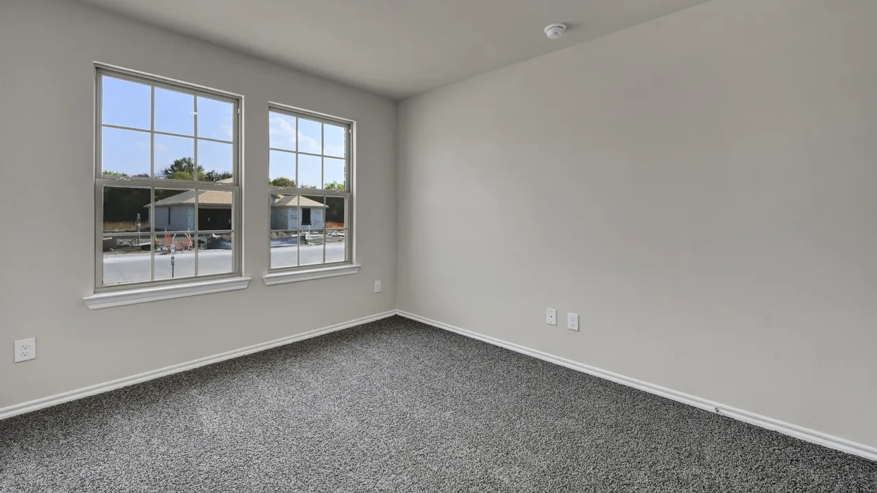 Carpeted flooring, two paneled windows, and light gray walls