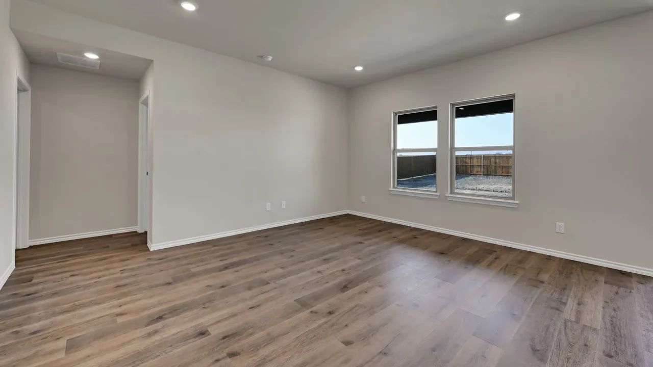 Recessed lighting, wood-finish flooring, light neutral wall paint, two windows, and white trim