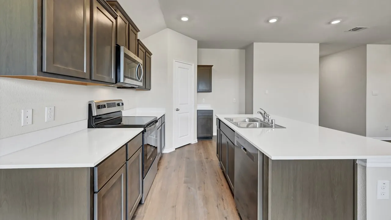 Kitchen with wood-finish flooring, white countertops, dark wood cabinetry, recessed lighting, and stainless steel appliances