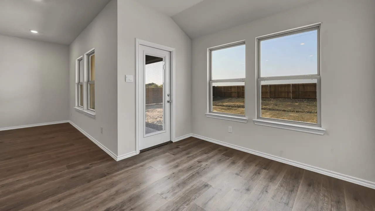 Vaulted ceiling accentuates the room, complemented by wood-finish flooring