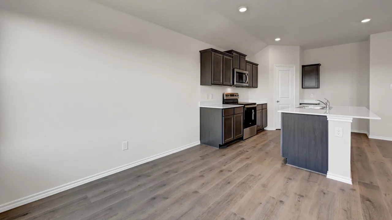 Kitchen featuring dark wood-finish cabinetry, stainless steel appliances, white countertops, and wood-finish flooring
