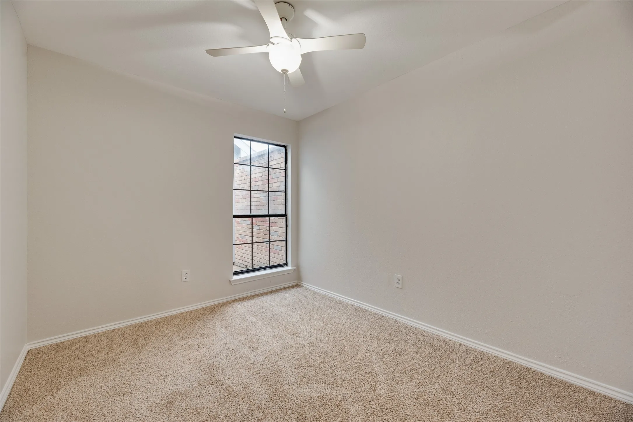 Carpeted flooring, neutral wall tones, and a ceiling fan with integrated lighting