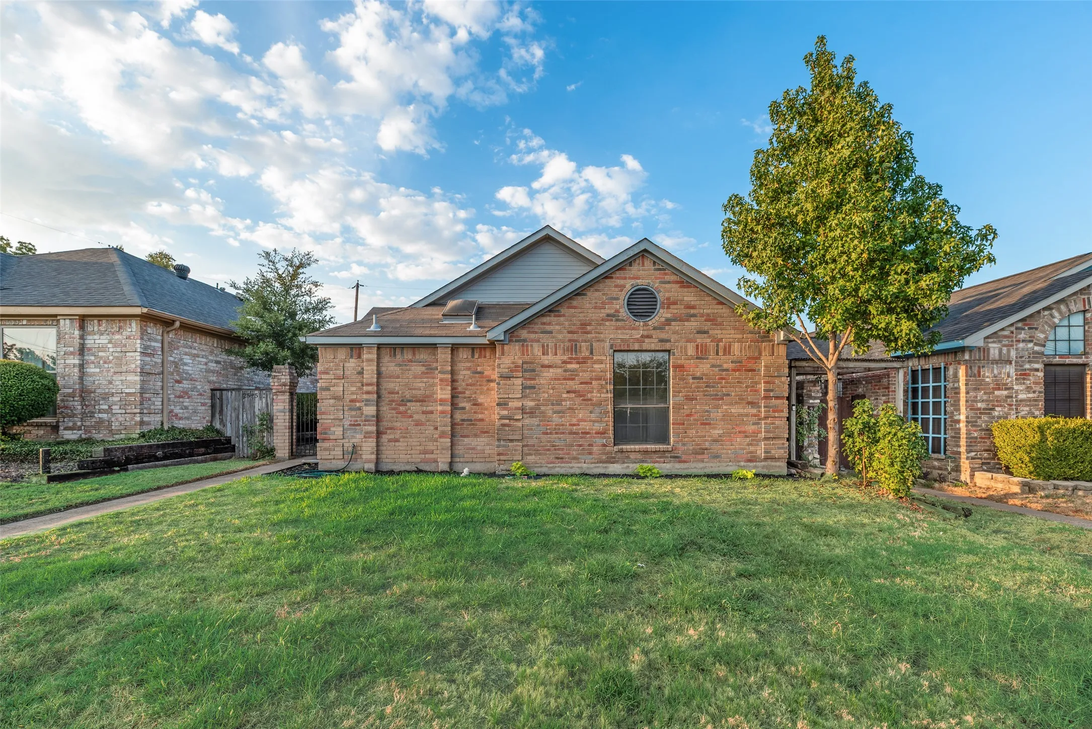 Brick exterior with a gabled roofline and round accent window