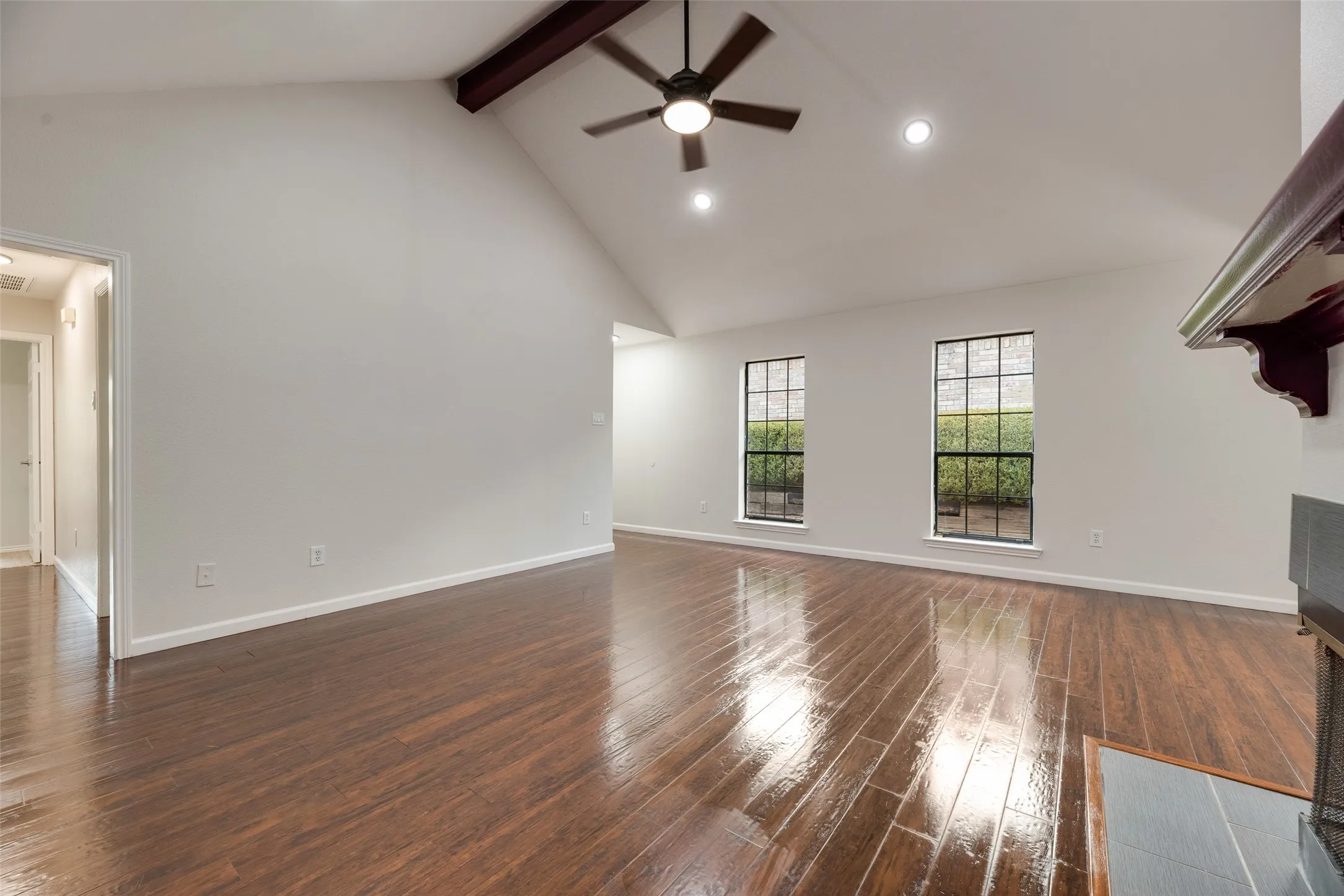Vaulted ceiling with exposed beam, wood-finish flooring, recessed lighting, and a ceiling fan