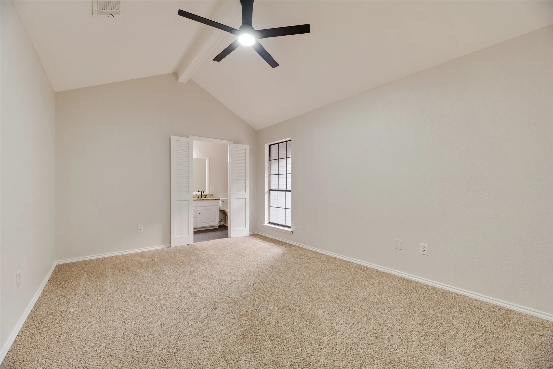 Vaulted ceiling, carpet flooring, ceiling fan, and double-pane window