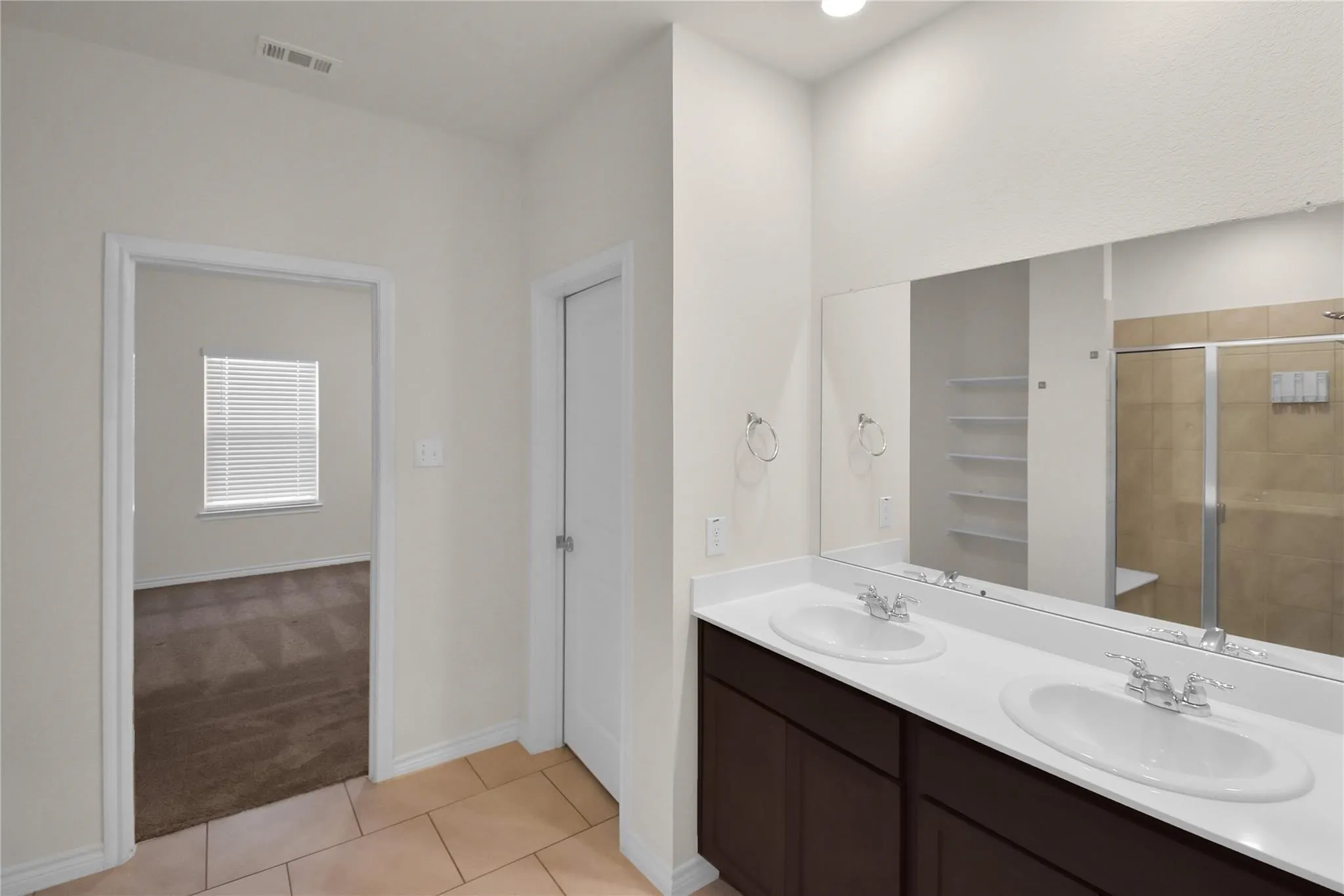 Dual vanity with white countertops, integrated sinks, and chrome fixtures