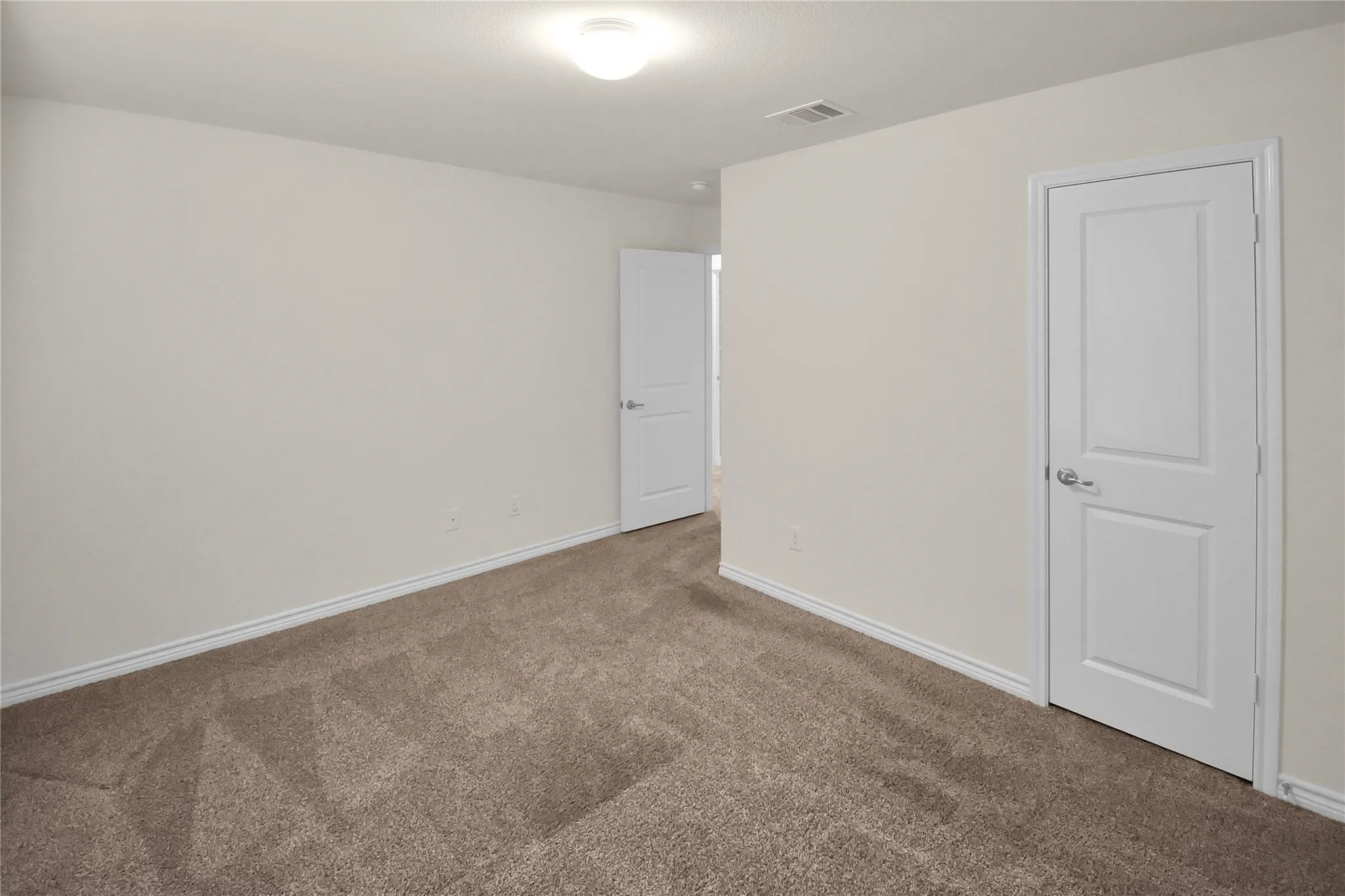 Neutral-toned walls, textured carpeting, and white interior doors