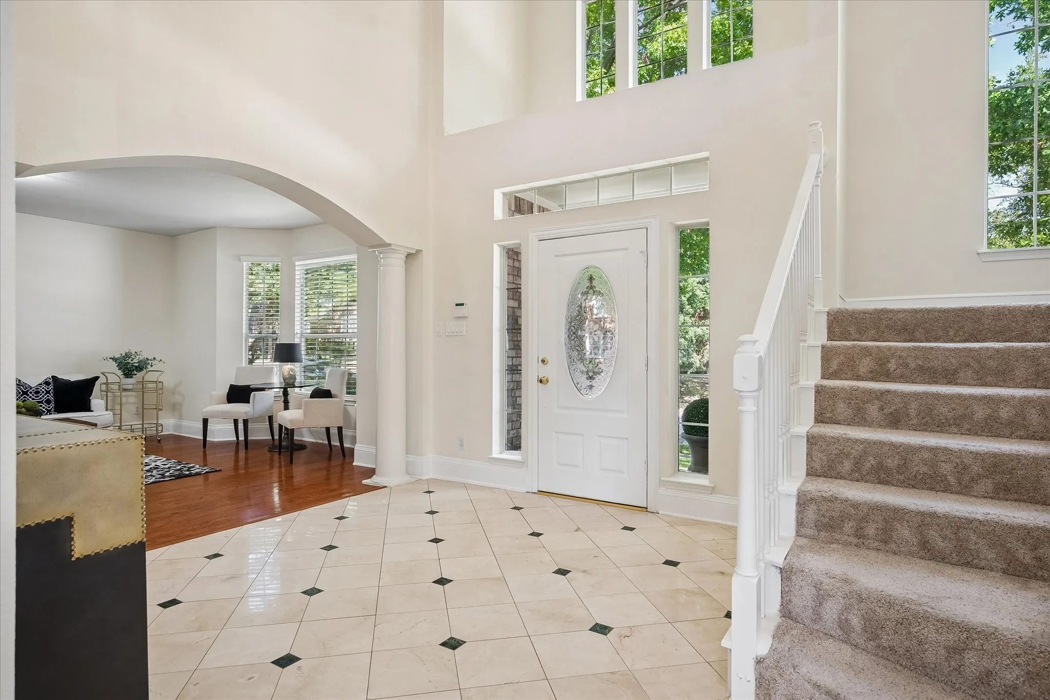 Two-story foyer with a decorative glass front door, side light windows, and transom window