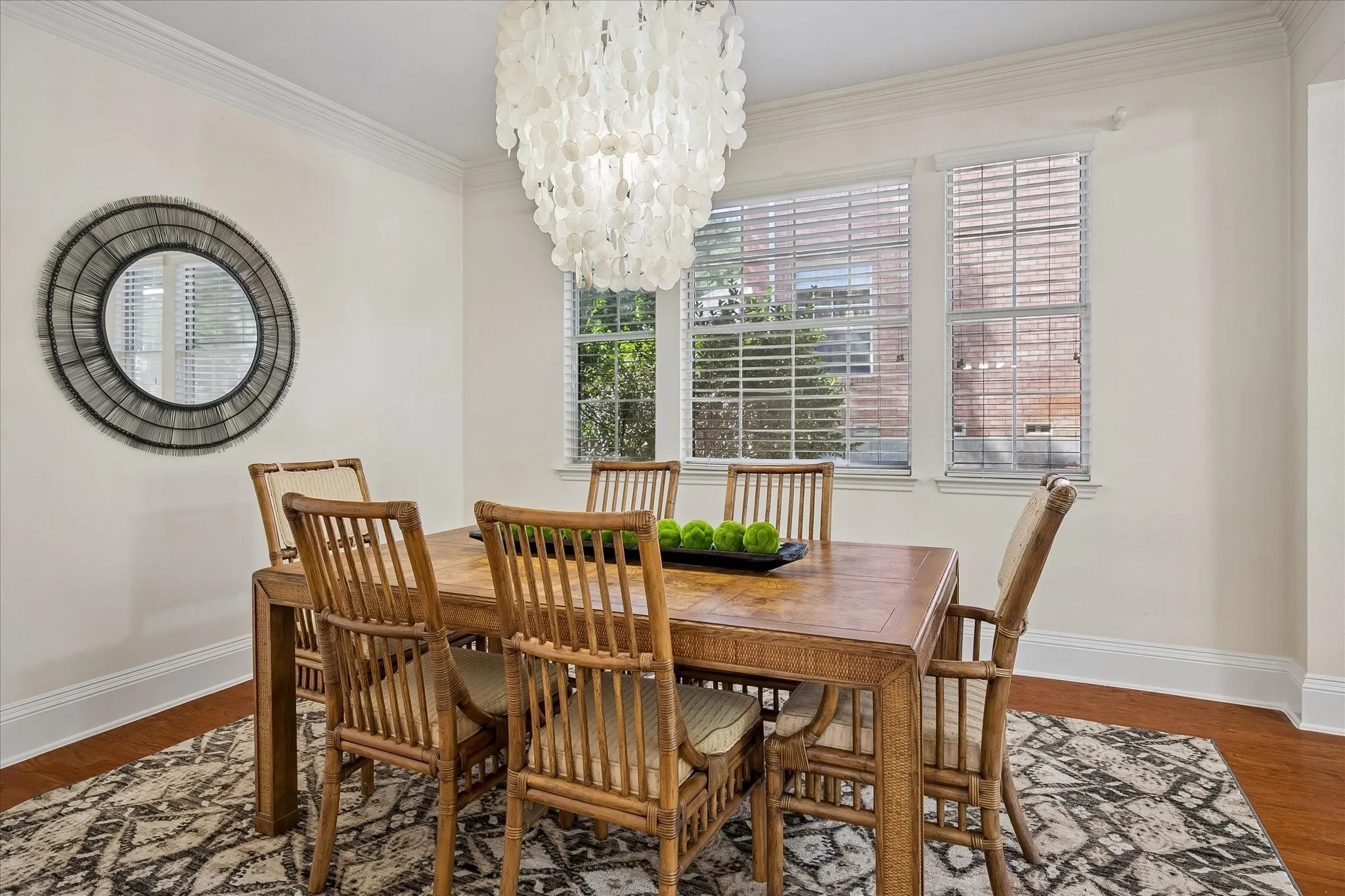 Crown molding accents, hardwood flooring, and a multi-pane window with white blinds
