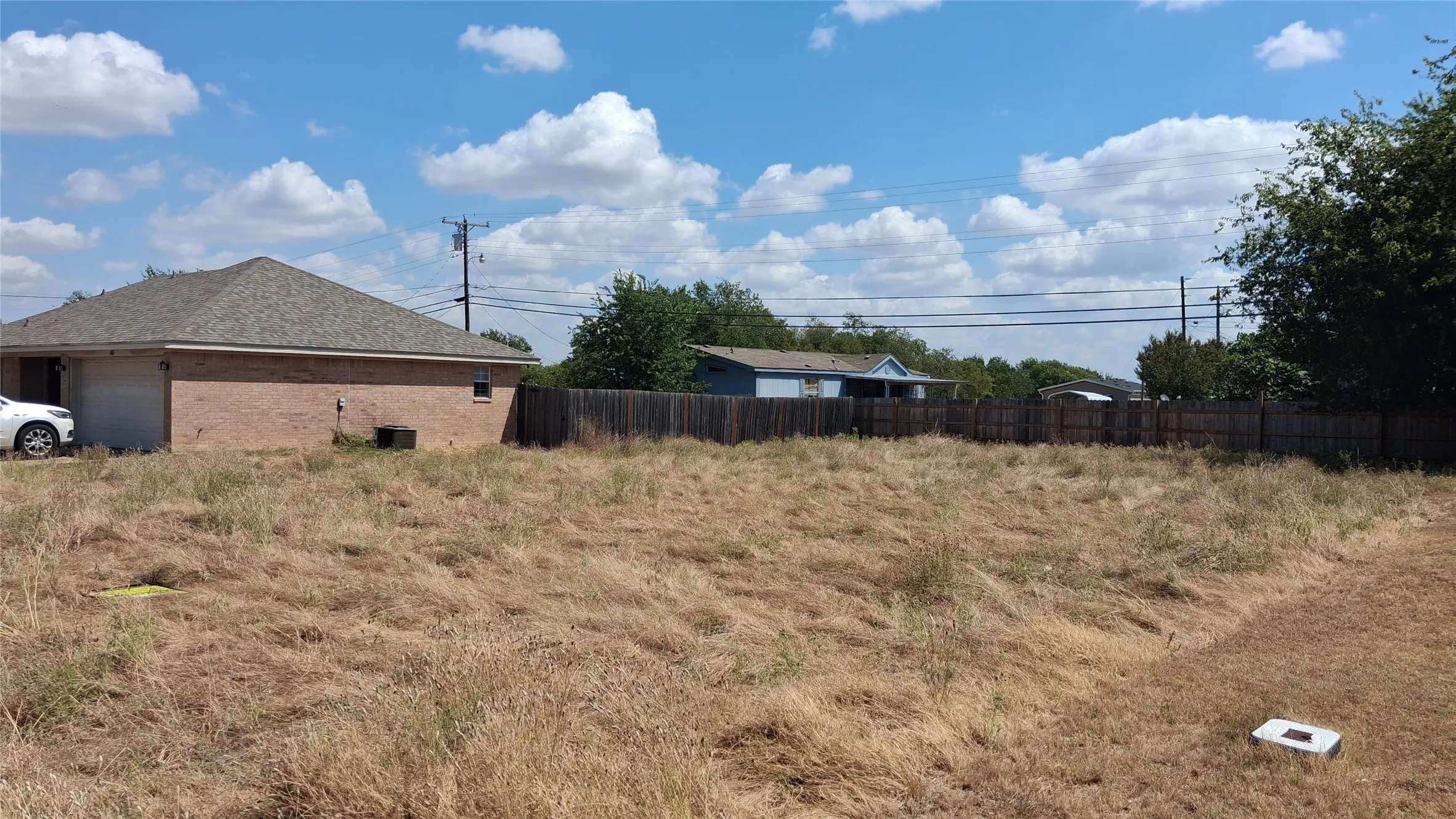 Expansive undeveloped lot with existing perimeter fencing and mature trees
