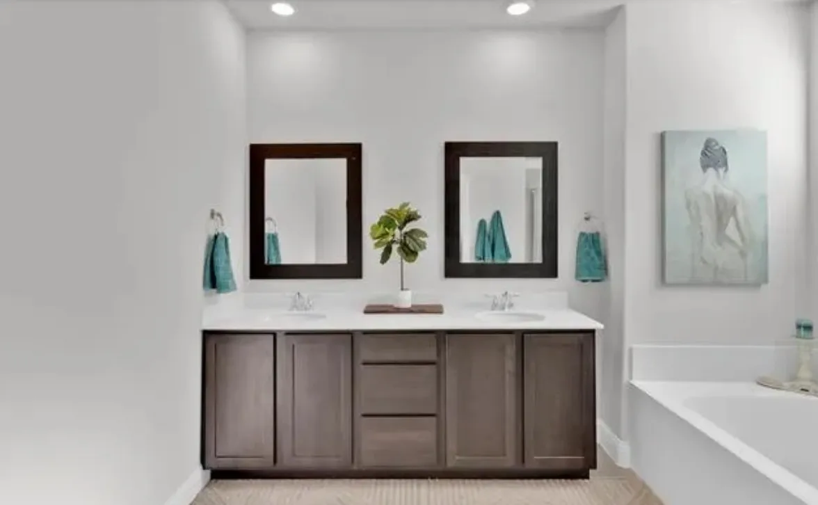 Dual vanity with dark wood-finish cabinetry, white countertops, and integrated sinks