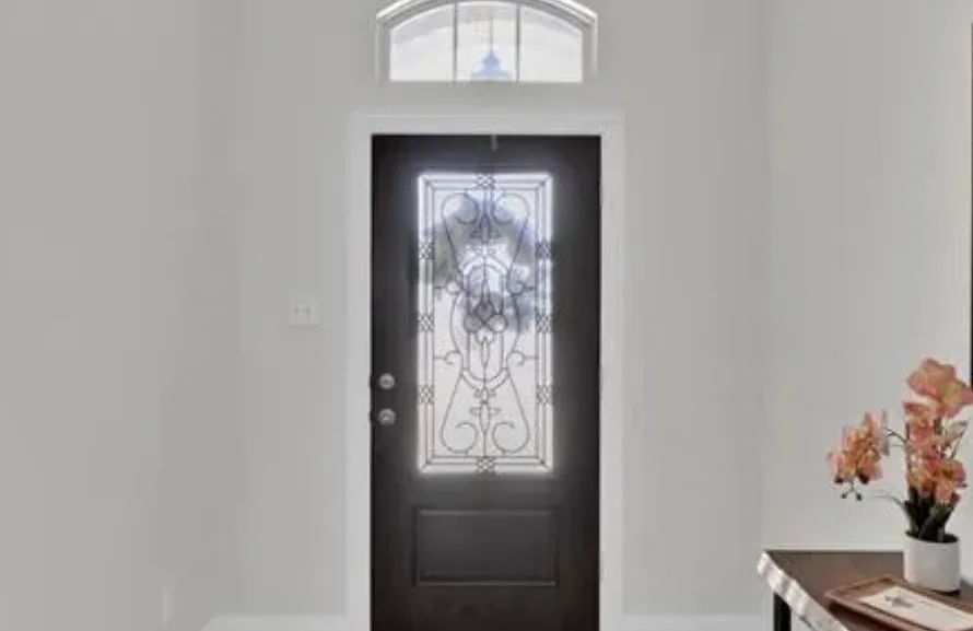 Front entry door with an arched transom window and decorative glass paneling
