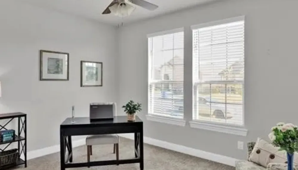 Two large windows with white blinds, neutral wall paint, and a ceiling fan with integrated lighting
