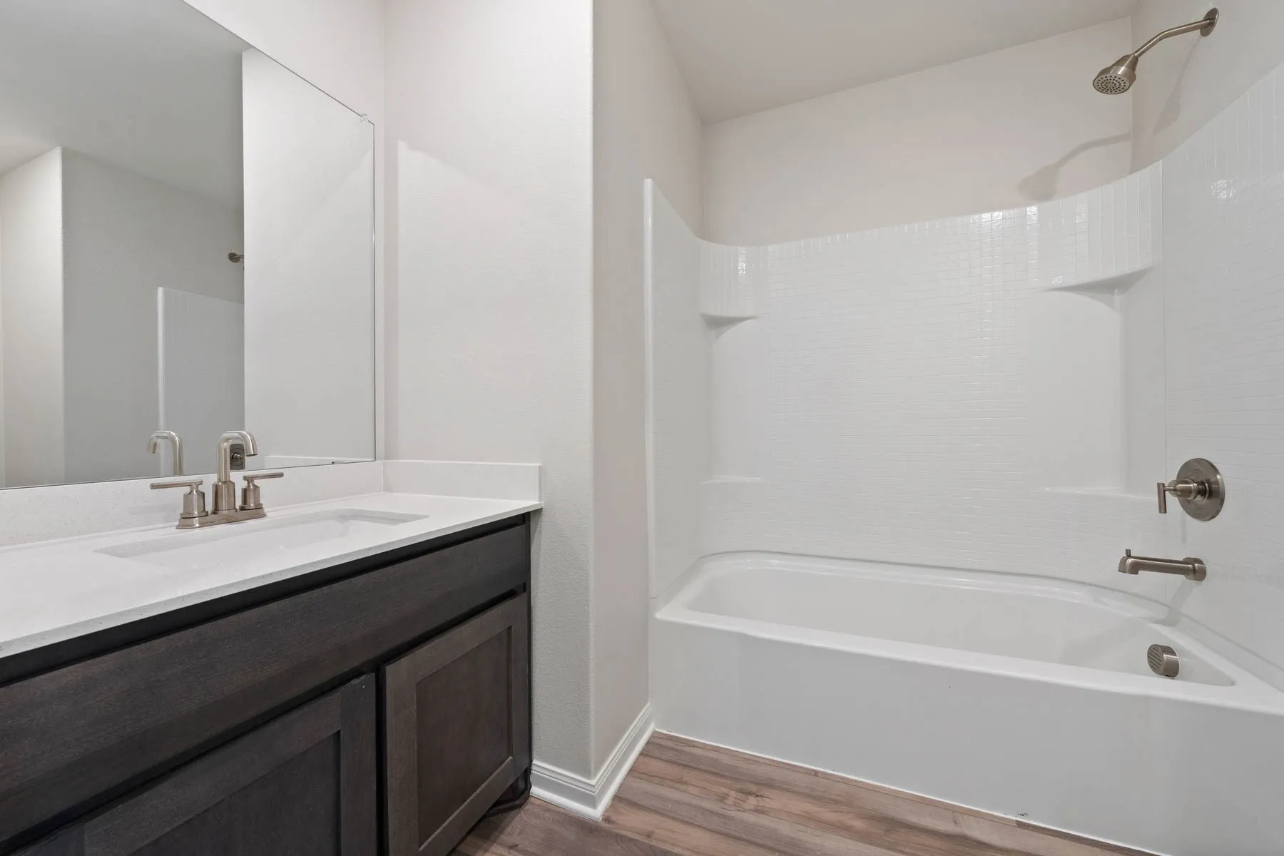 Bathroom featuring vanity, wood-type flooring, and bathtub / shower combination