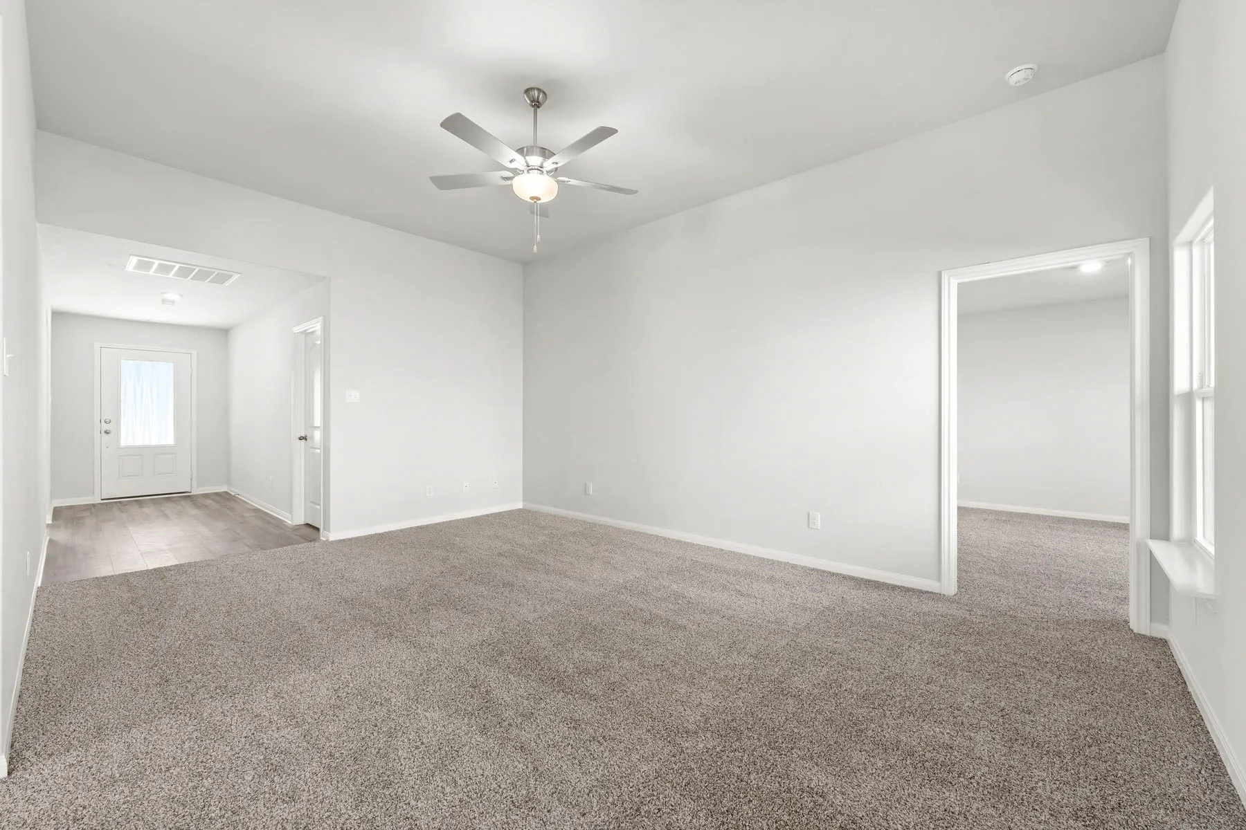 Carpeted empty room with ceiling fan