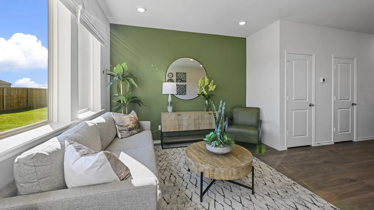 Recessed lighting illuminating the interior, large windows, an accent wall, and wood-finish flooring