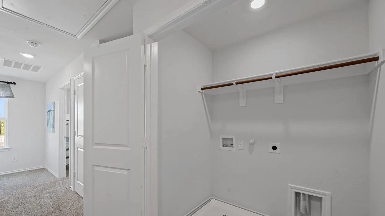 Laundry area with built-in shelving, clothing rod, and utility hookups