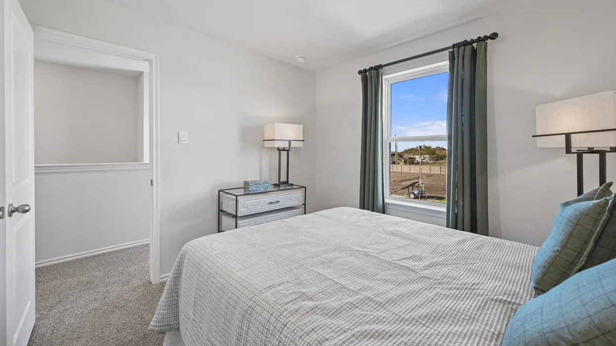 Carpeted room with a single window, white walls, and a white door
