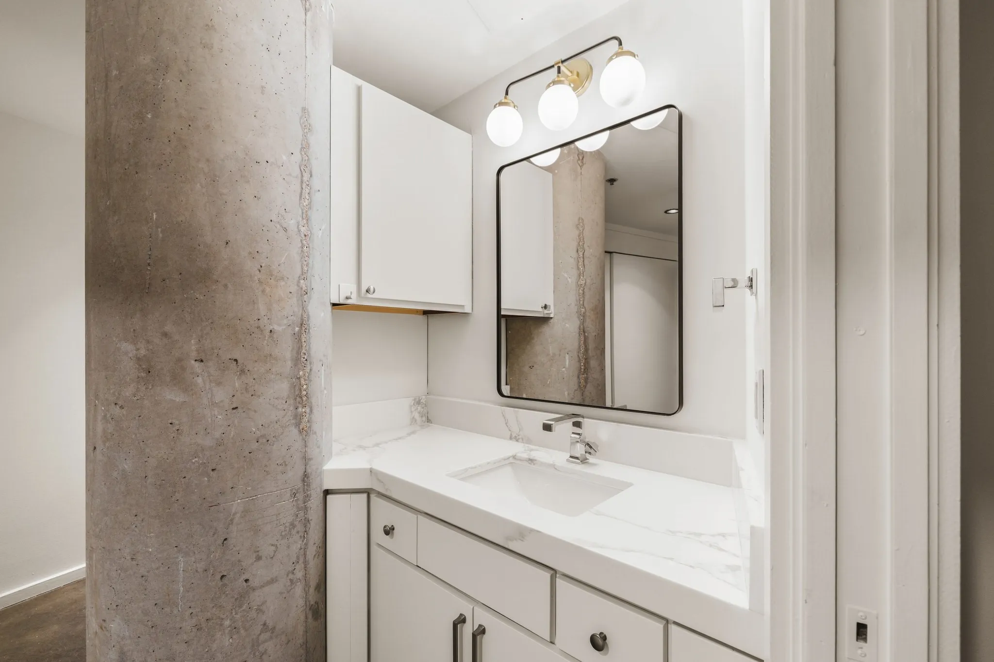 White vanity with a rectangular undermount sink, a chrome faucet, and white countertops