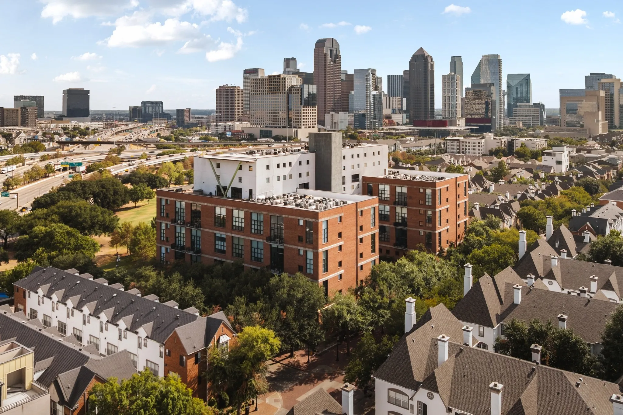 Expansive urban landscape featuring a dynamic skyline, a multi-lane highway, and varied residential architecture