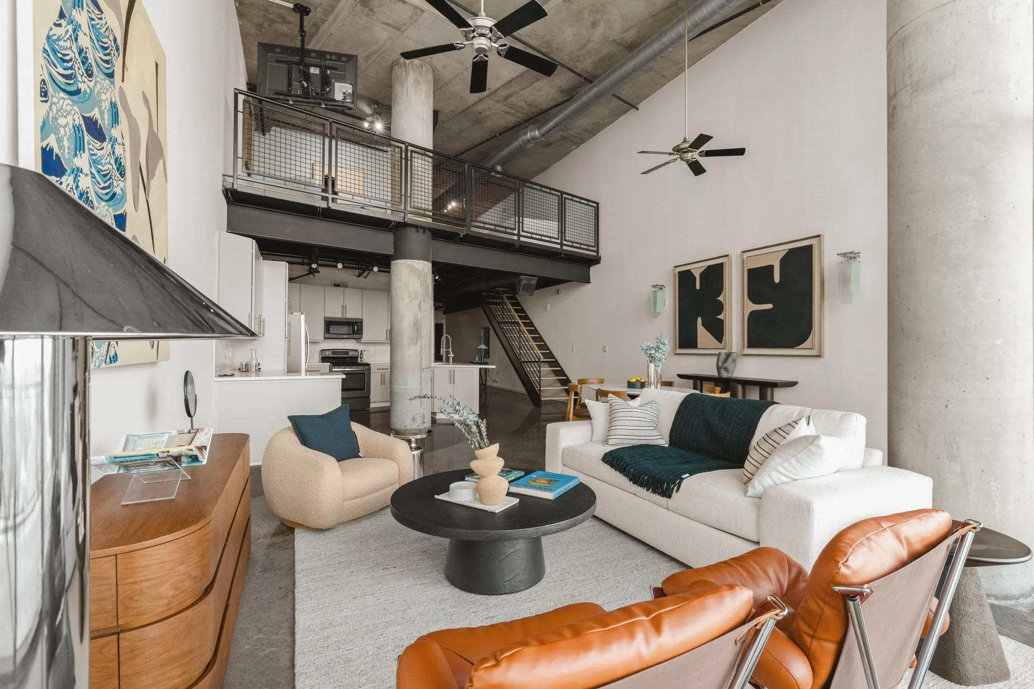 Vaulted ceiling, exposed concrete ceiling, industrial-style loft, mezzanine level, and open-concept living area