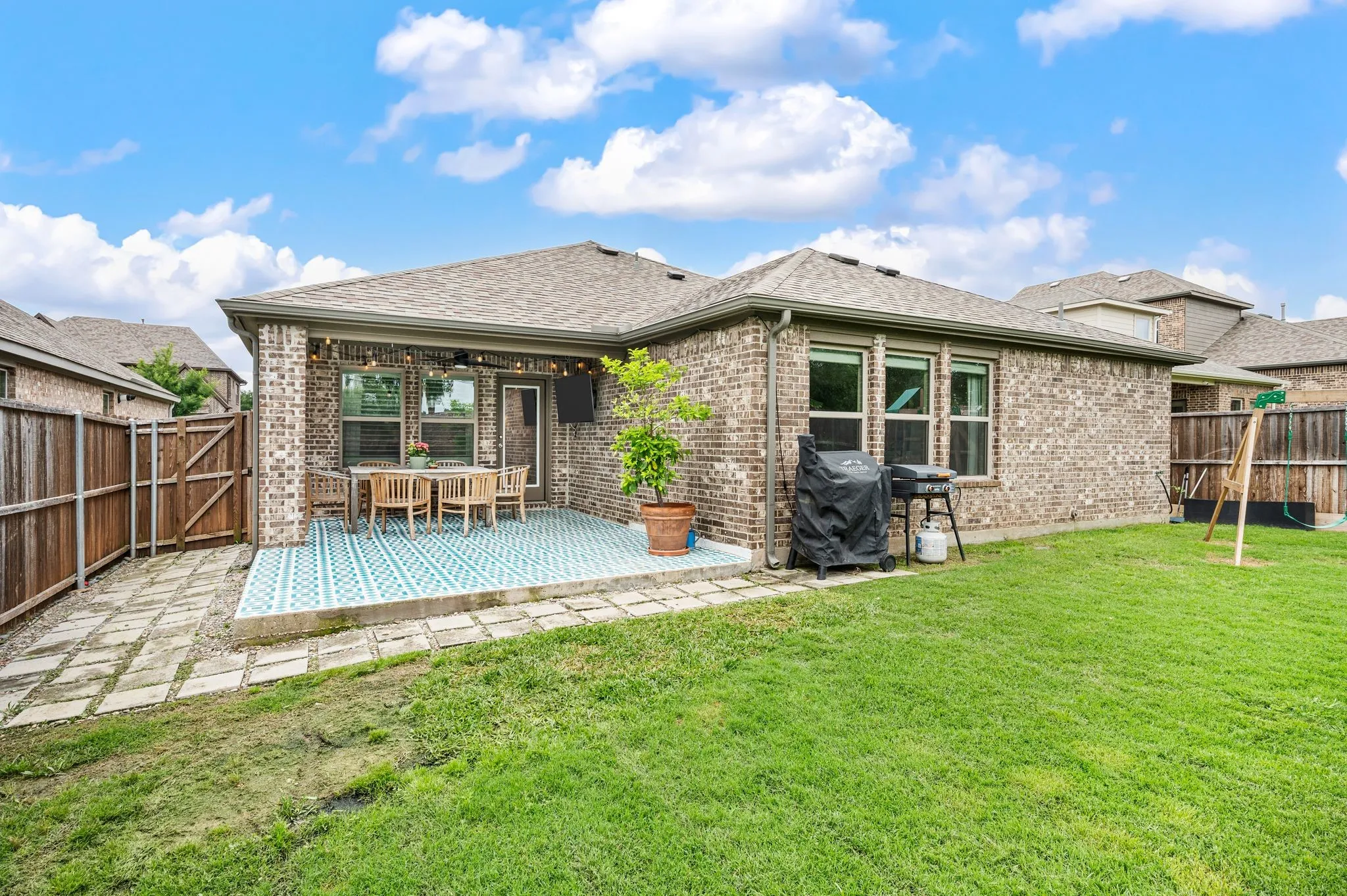 Wonderful backyard featuring a covered patio with extended patio flooring a paved walkway and a great sized backyard.