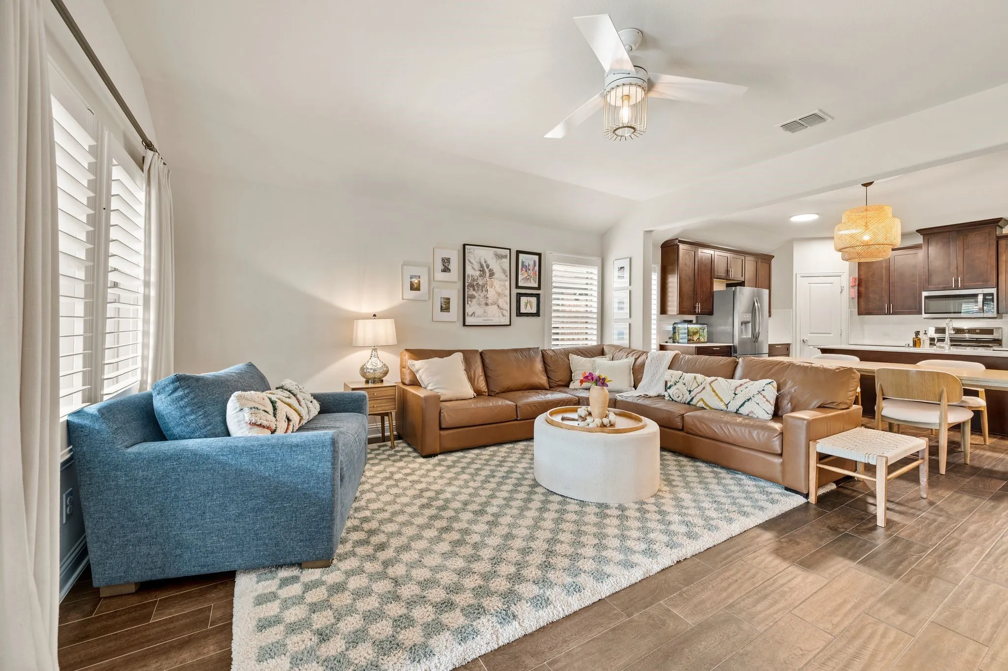 Spacious living area featuring updated flooring, a contemporary ceiling fan, and plantation shutters that have been upgraded that you can not get in a new build!