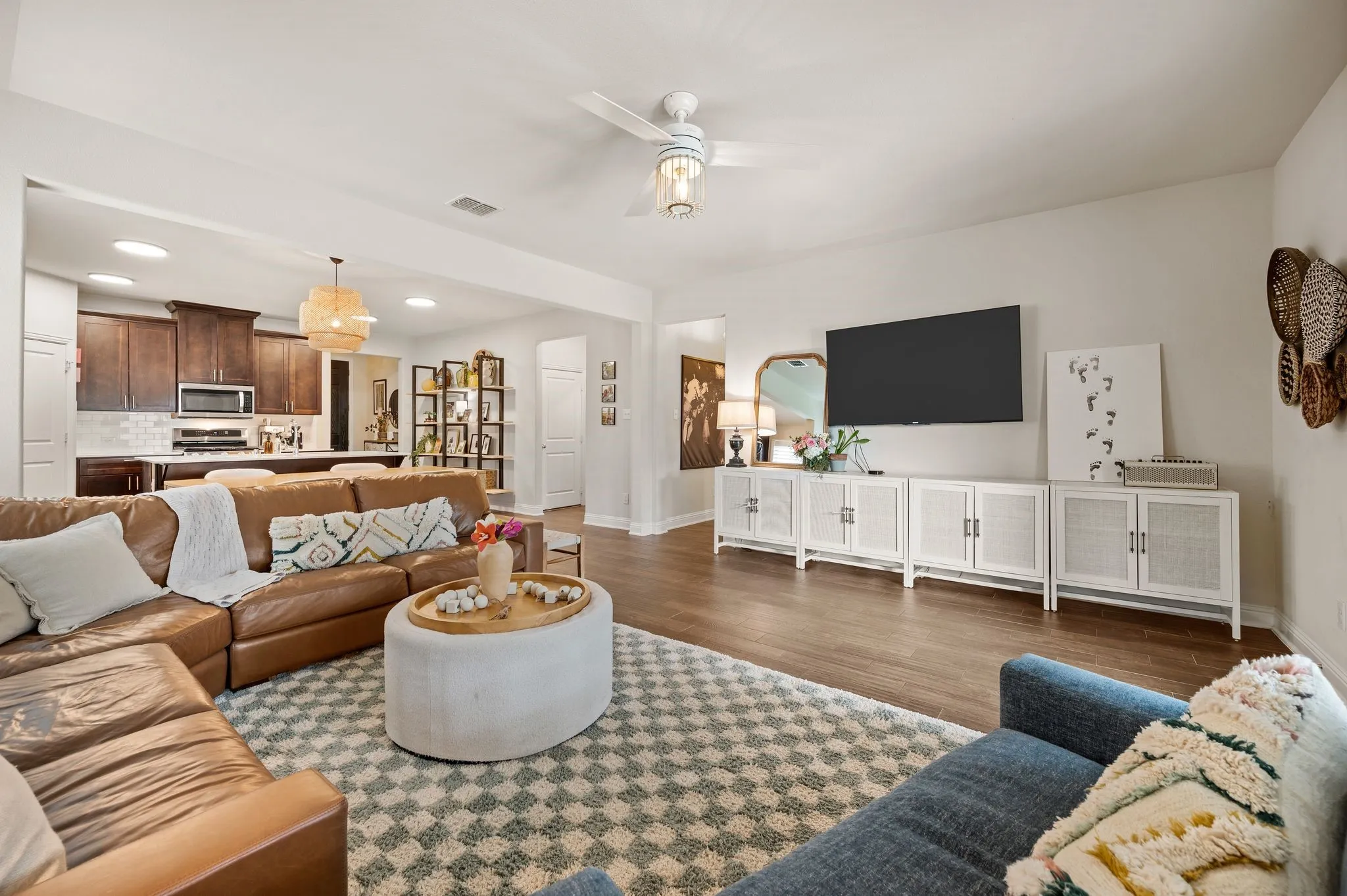 Open-concept living area with beautiful flooring, updated ceiling fan and wonderful natural light!