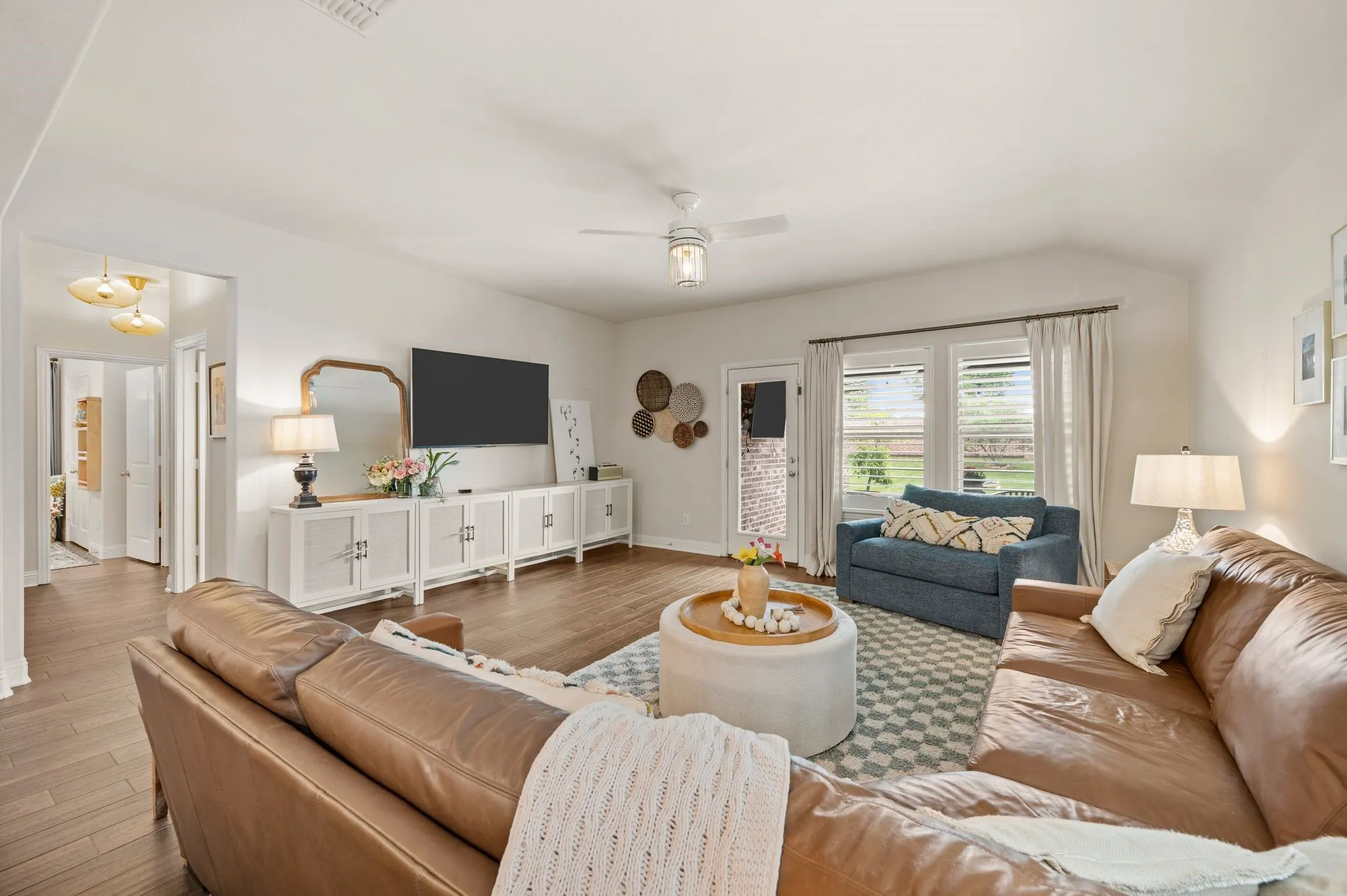 Spacious living area featuring updated beautiful flooring, plantation shutters and space for large furniture and your family and friends!