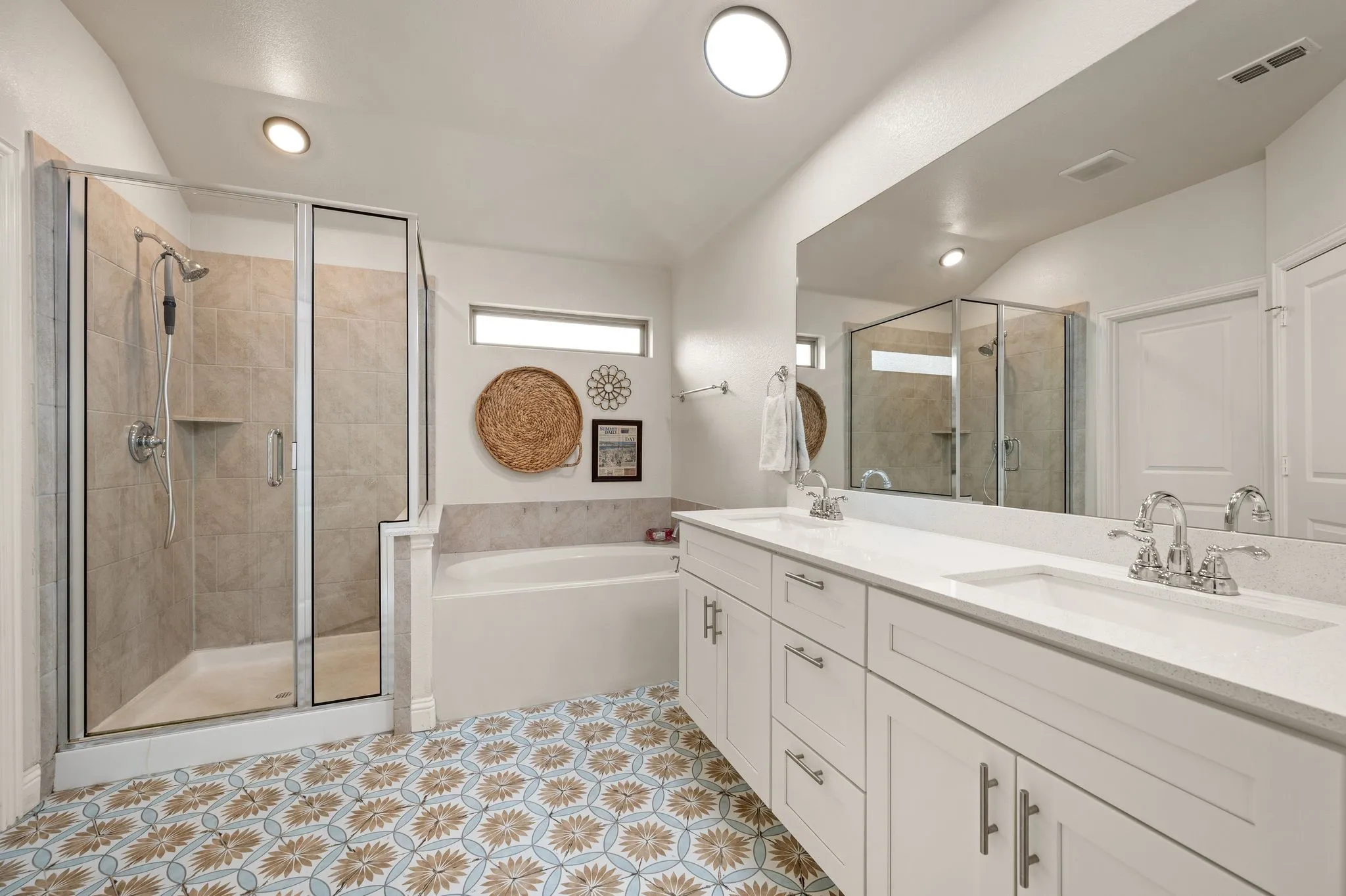 Private primary bathroom with dual sink vanity, white cabinetry, garden tub, separate shower and beautiful updated tile flooring.