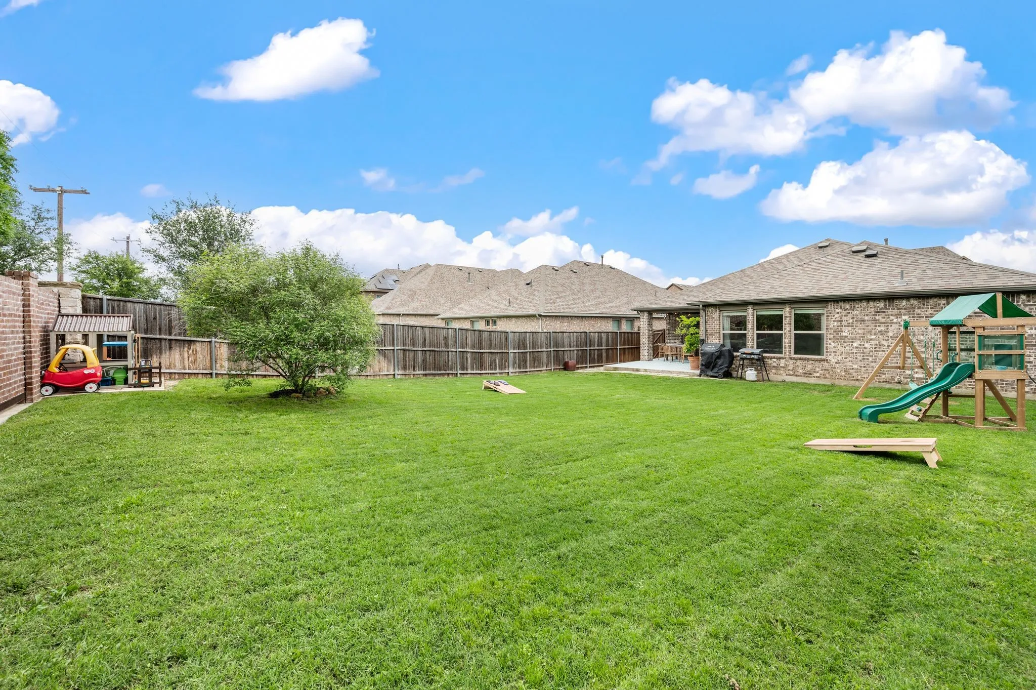 Expansive green lawn with a mature tree, with a privacy fence and more than enough room to put in a pool or a garden.  What would you do with this space?
