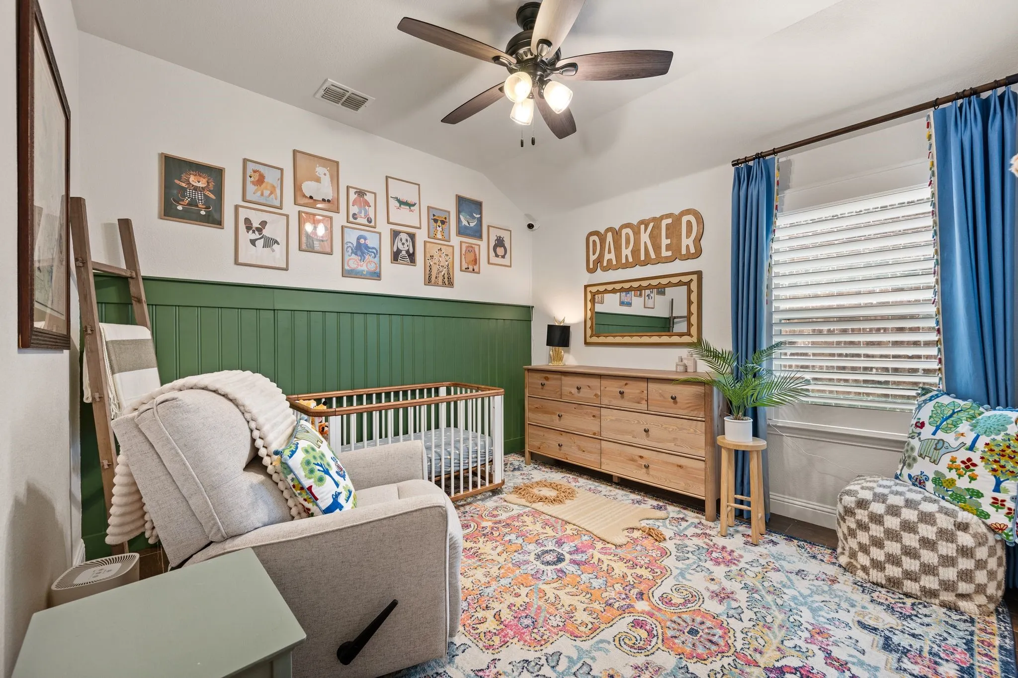 Guest bedroom with Tray ceiling with ceiling fan, beadboard wainscoting, and upgraded shutters on the window and beautiful flooring that is the same throughout the house