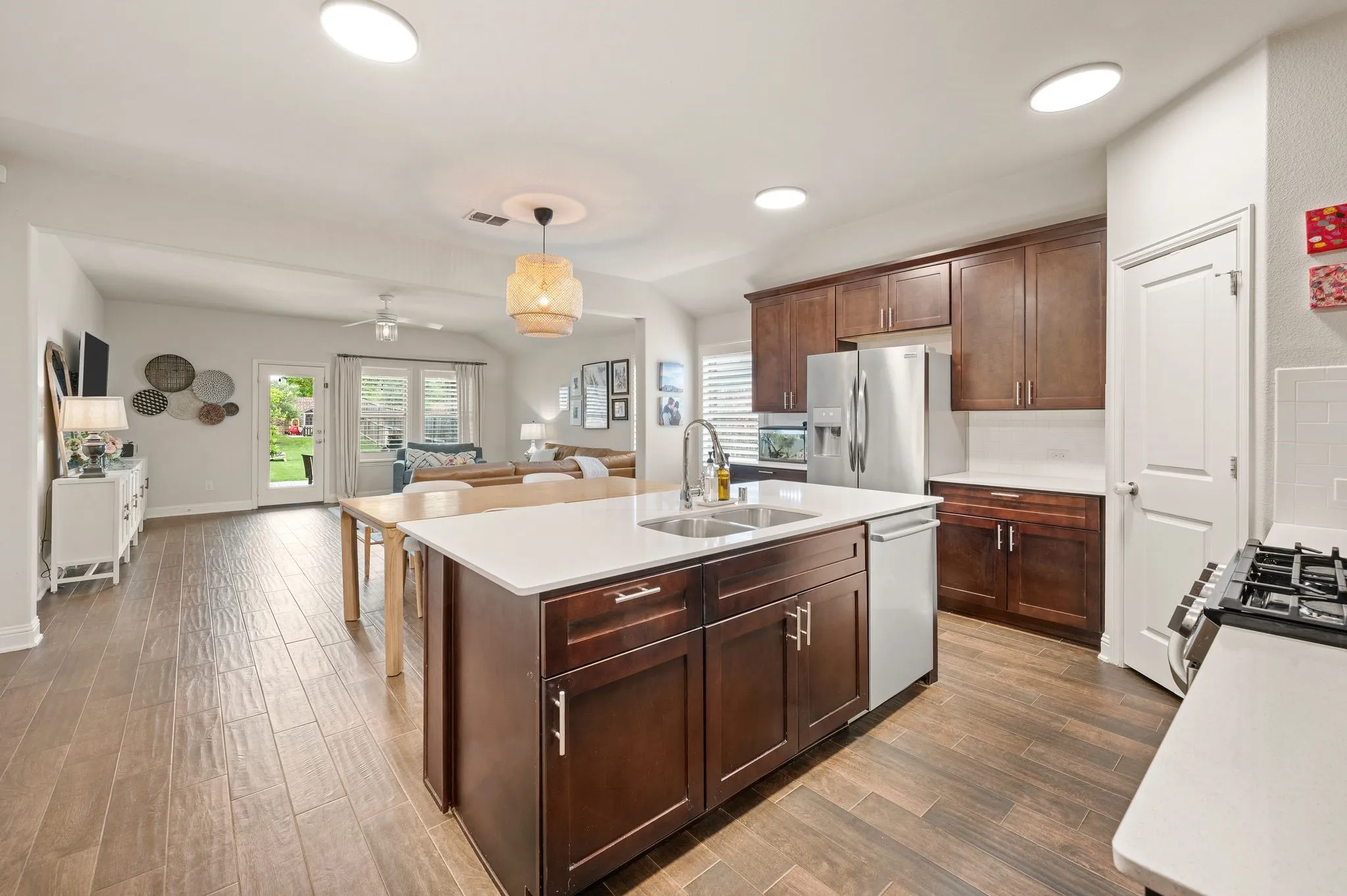 Open-concept kitchen and living area featuring beautiful flooring, recessed lighting, a kitchen island with sink, and beautiful cabinetry